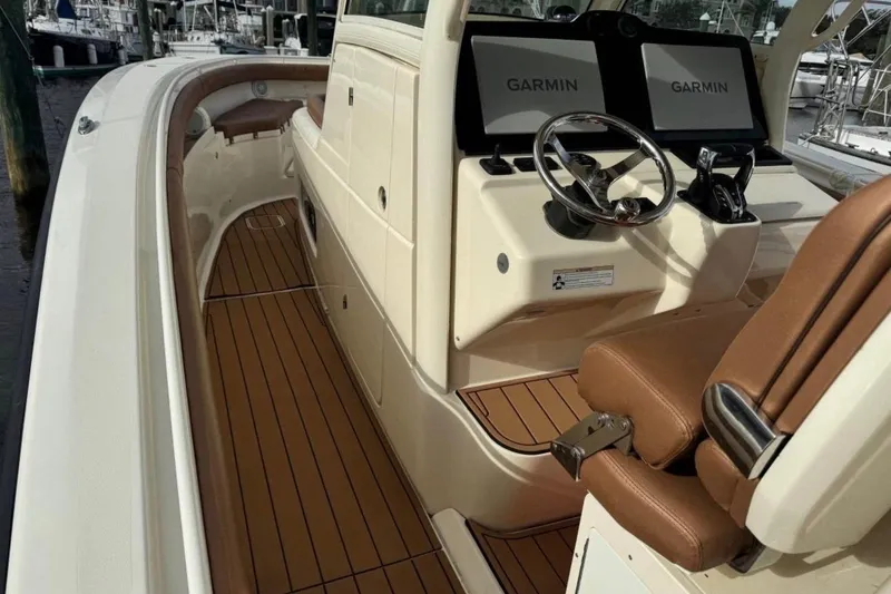 Slide: The Image of 2017 Scout 350 LXF boat interior with Garmin displays and brown seating. - 62
