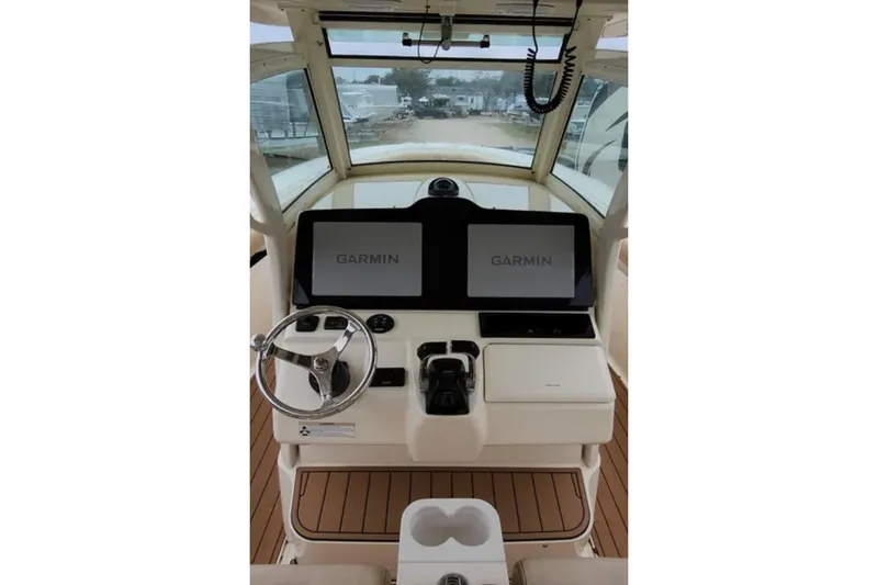 Slide: The Image of 2017 Scout 350 LXF boat helm with dual Garmin displays and steering wheel. - 63
