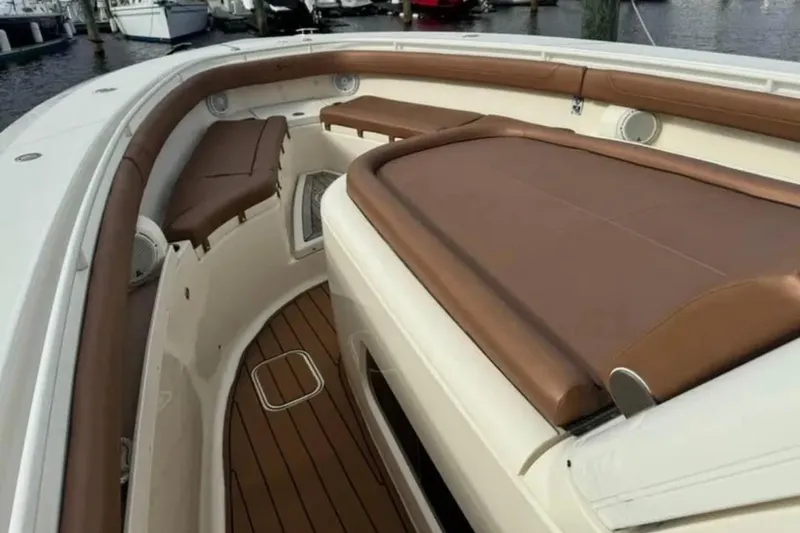 Slide: The Image of 2017 Scout 350 LXF boat interior with brown leather seating and wood flooring. - 67