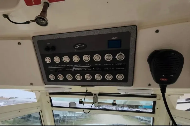 Slide: The Image of Control panel of a 2017 Scout 350 LXF boat with various switches and a microphone. - 76
