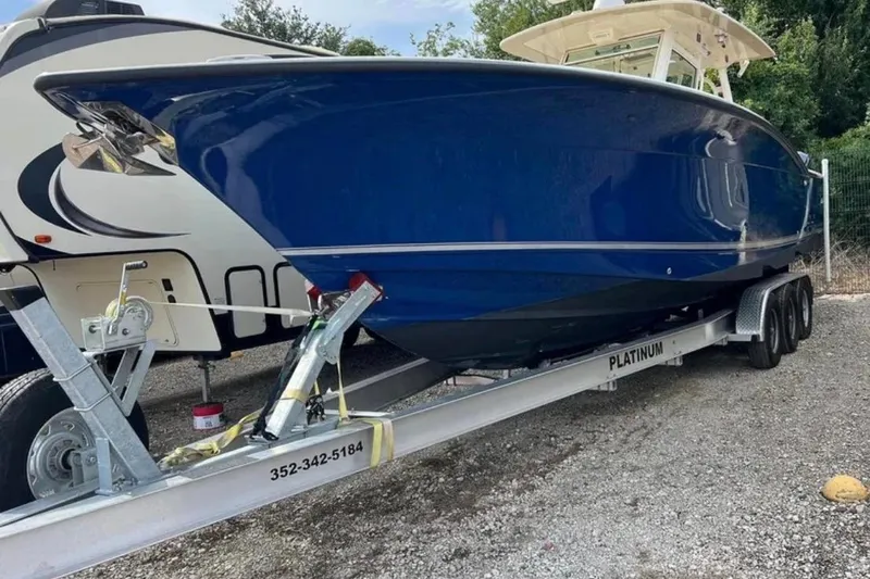 Slide: The Image of 2017 Scout 350 LXF boat on trailer, blue hull, parked outdoors. - 81