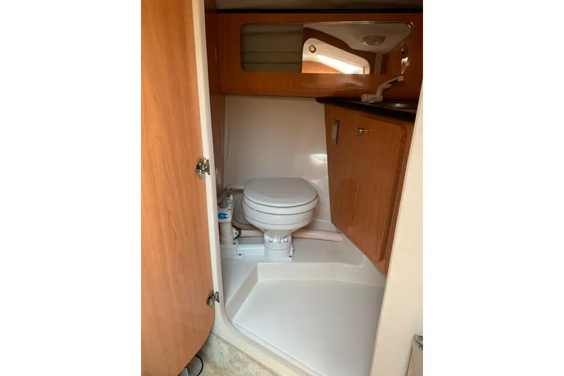 Slide: The Image of 1999 Regal 2850 LSC boat bathroom with wooden cabinetry and compact toilet. - 10