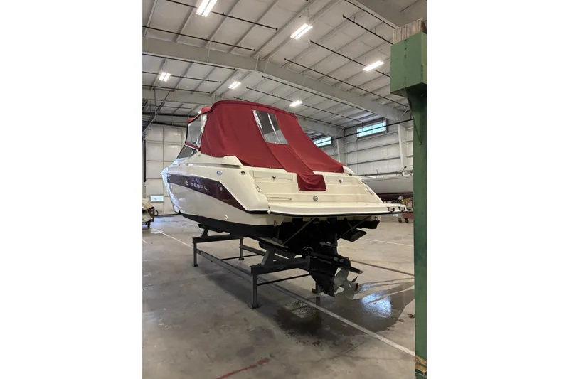 Slide: The Image of 1999 Regal 2850 LSC boat with red cover in indoor storage facility. - 17