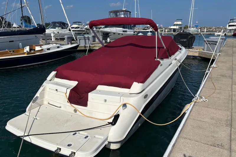 Slide: The Image of 1999 Regal 2850 LSC boat docked with maroon cover, marina background. - 4