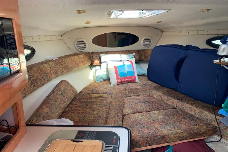 Slide: The Image of Interior of 1999 Regal 2850 LSC boat with cozy seating and cushions. - 9