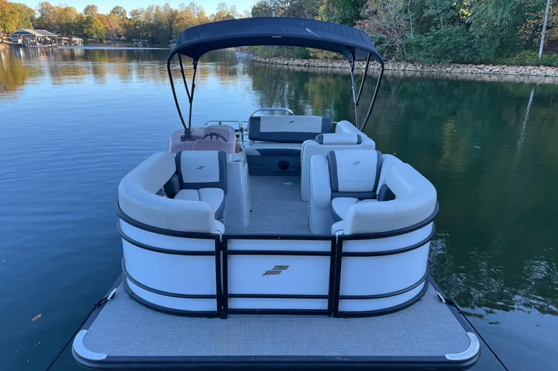 Slide: The Image of 2025 Starcraft EXS 3 Q DH pontoon boat on a serene lake. - 2