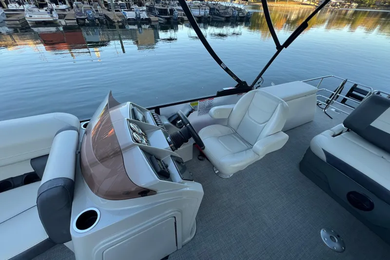 Slide: The Image of 2025 Starcraft EXS 3 Q DH boat interior with helm and seating, docked at marina. - 5