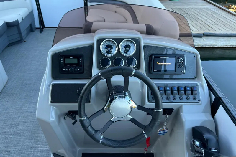 Slide: The Image of 2025 Starcraft EXS 3 Q DH boat dashboard with steering wheel and control panel. - 6