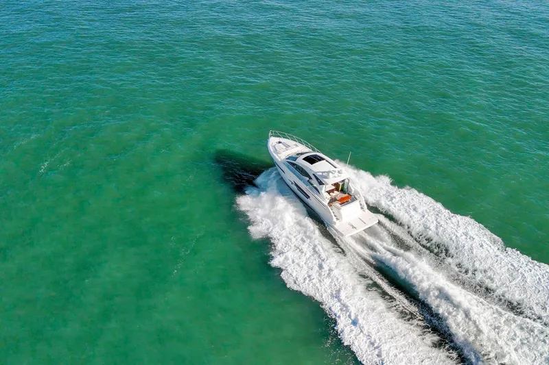 Slide: The Image of 2019 Cruisers Yachts 54 Cantius cruising on clear turquoise waters. - 109