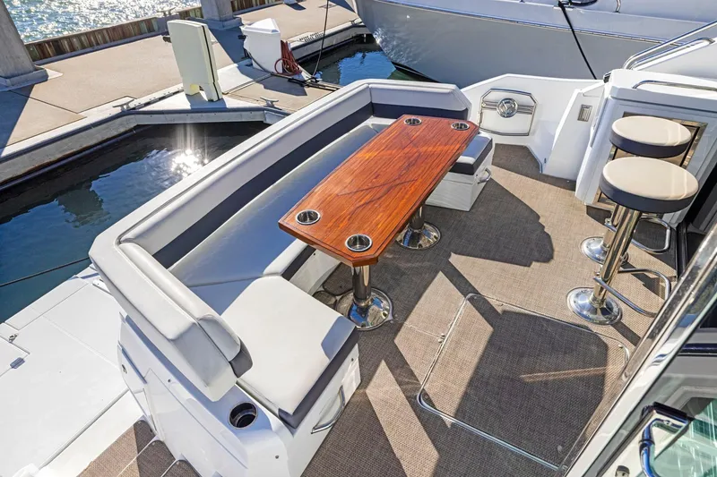Slide: The Image of 2019 Cruisers Yachts 54 Cantius deck with seating and wooden table. - 12