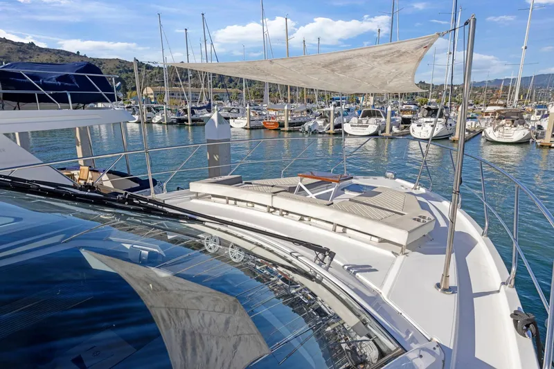 Slide: The Image of 2019 Cruisers Yachts 54 Cantius docked in a marina, surrounded by sailboats. - 14