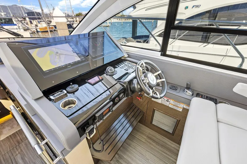 Slide: The Image of 2019 Cruisers Yachts 54 Cantius helm with modern navigation displays and steering wheel. - 36