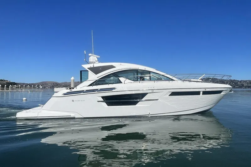 Slide: The Image of 2019 Cruisers Yachts 54 Cantius on calm water under clear blue sky. - 7