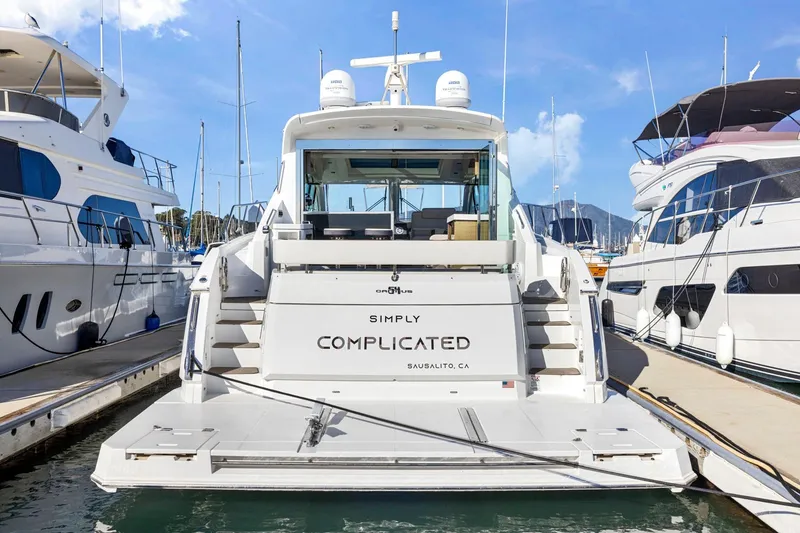 Slide: The Image of 2019 Cruisers Yachts 54 Cantius docked, rear view, with "Simply Complicated" nameplate. - 9
