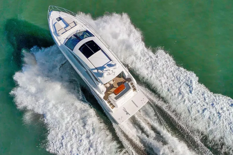Slide: The Image of 2019 Cruisers Yachts 54 Cantius speeding on turquoise water, aerial view. - 108