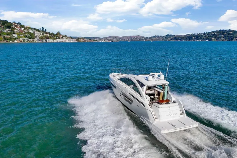 Slide: The Image of 2019 Cruisers Yachts 54 Cantius cruising on blue waters near scenic coastline. - 110