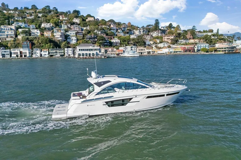 Slide: The Image of 2019 Cruisers Yachts 54 Cantius sailing near scenic coastal town. - 114