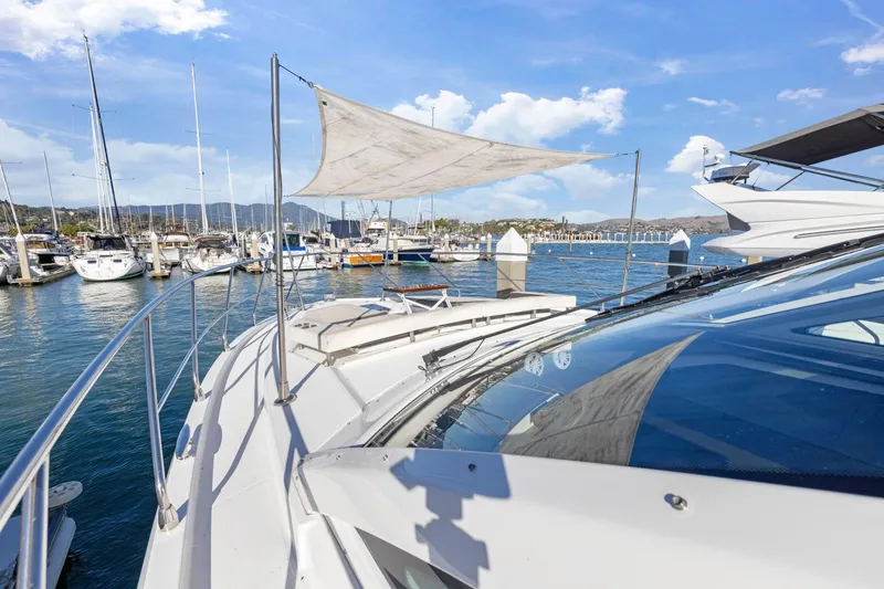 Slide: The Image of 2019 Cruisers Yachts 54 Cantius docked at a marina under a clear blue sky. - 17