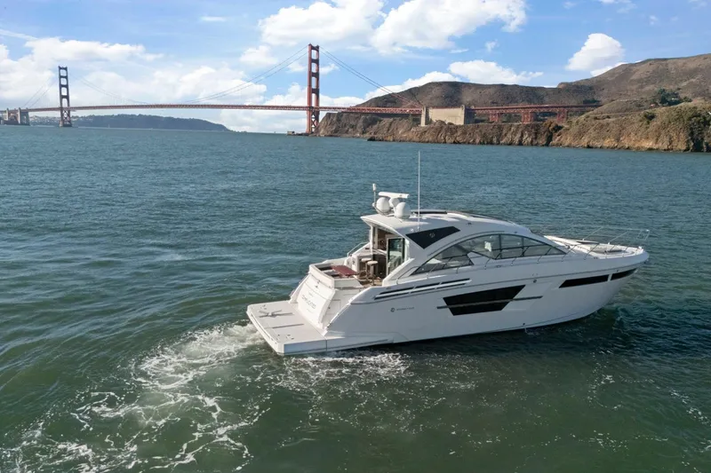 Slide: The Image of 2019 Cruisers Yachts 54 Cantius sailing near iconic bridge on a sunny day. - 82