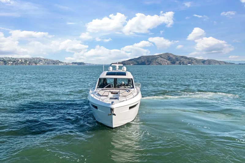 Slide: The Image of 2019 Cruisers Yachts 54 Cantius on open water with scenic mountain backdrop. - 92