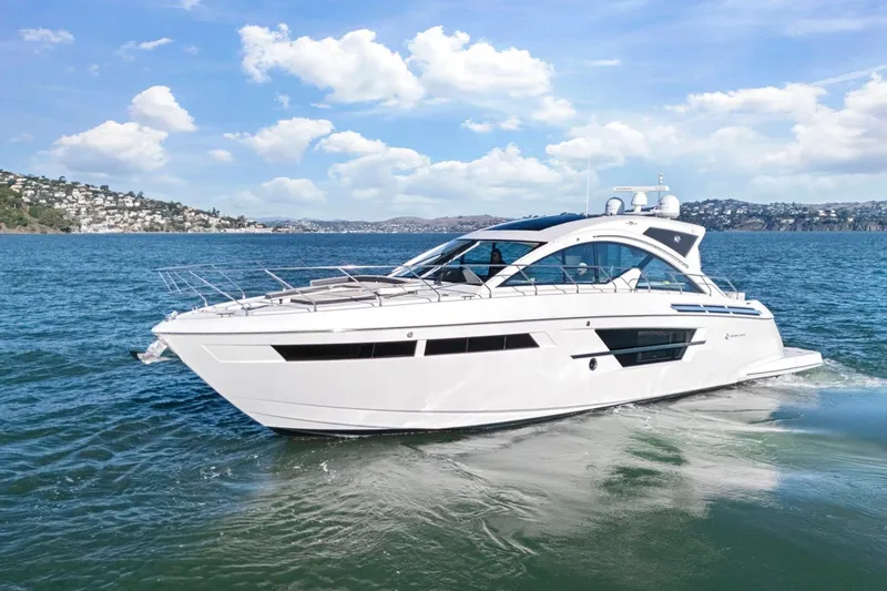 Slide: The Image of 2019 Cruisers Yachts 54 Cantius cruising on a sunny day, scenic coastal backdrop. - 93