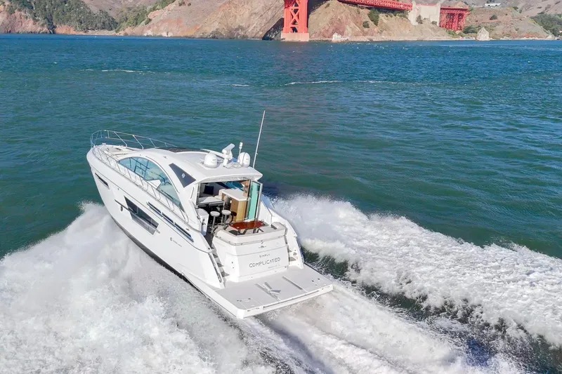 Slide: The Image of 2019 Cruisers Yachts 54 Cantius cruising near a bridge on open water. - 99