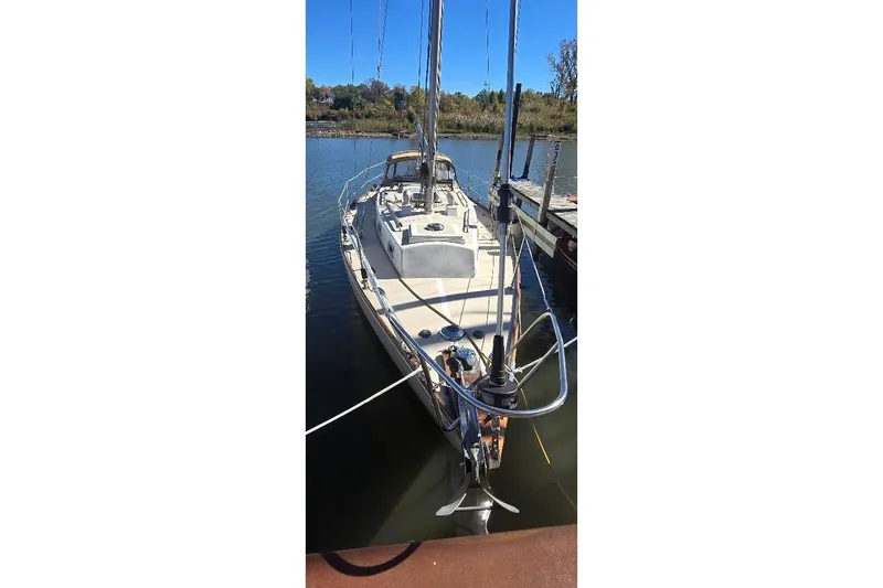 Slide: The Image of 1978 Tartan T34c sailboat docked on calm water, viewed from the bow. - 2