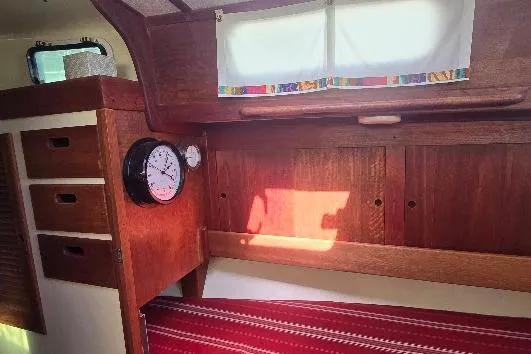 Slide: The Image of 1978 Tartan T34c sailboat interior with wooden cabinetry and nautical clock. - 52