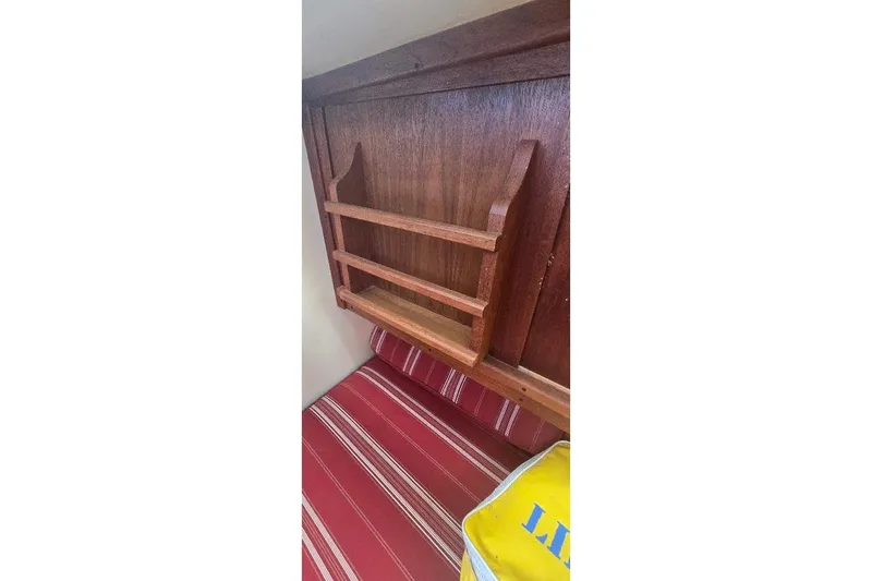 Slide: The Image of Wooden interior of 1978 Tartan T34c sailboat with striped red cushion. - 55