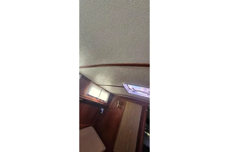 Slide: The Image of Interior cabin view of a 1978 Tartan T34c sailboat, featuring a textured ceiling and wooden accents. - 90