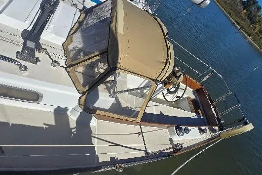 Slide: The Image of 1978 Tartan T34c sailboat with beige canopy, docked on calm water. - 14