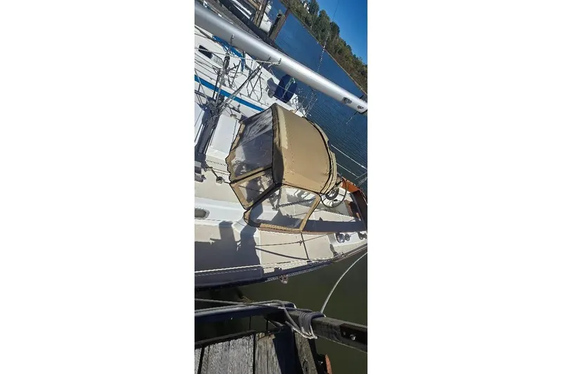 Slide: The Image of 1978 Tartan T34c sailboat docked, featuring a beige canopy and sleek design. - 15