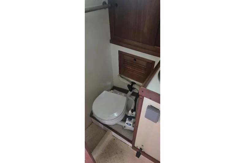 Slide: The Image of 1978 Tartan T34c sailboat bathroom with wooden cabinetry and compact toilet. - 22
