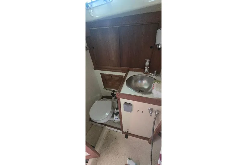 Slide: The Image of 1978 Tartan T34c yacht bathroom with sink, toilet, and wooden cabinetry. - 24