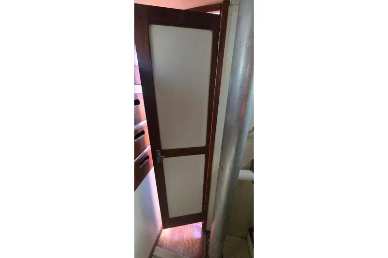 Slide: The Image of Wooden door inside 1978 Tartan T34c sailboat, partially open, revealing interior details. - 28