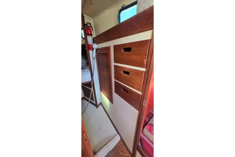 Slide: The Image of 1978 Tartan T34c interior with wooden cabinets and fire extinguisher. - 30