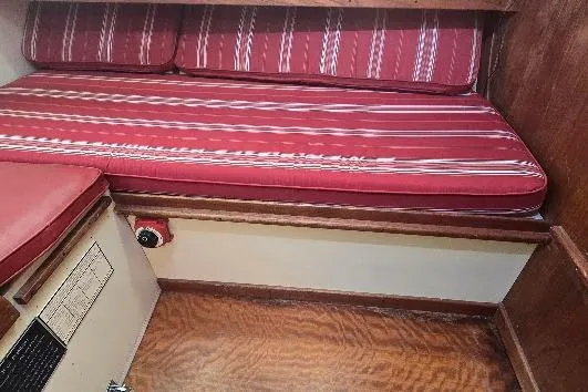 Slide: The Image of 1978 Tartan T34c interior with red-striped cushions and wooden flooring. - 46