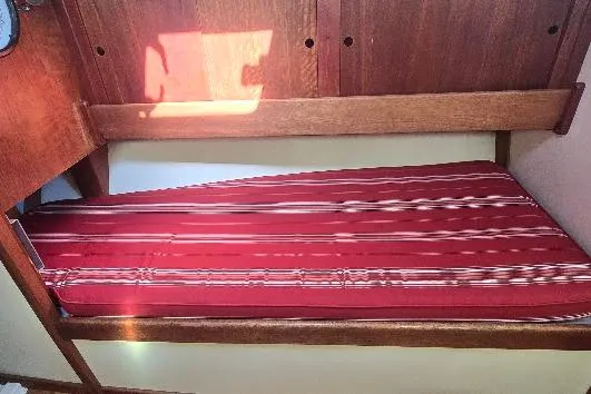 Slide: The Image of 1978 Tartan T34c sailboat interior with red-striped bunk bed. - 48