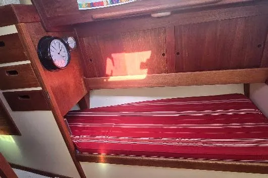 Slide: The Image of Interior of 1978 Tartan T34c sailboat with red-striped bunk and wooden cabinetry. - 51