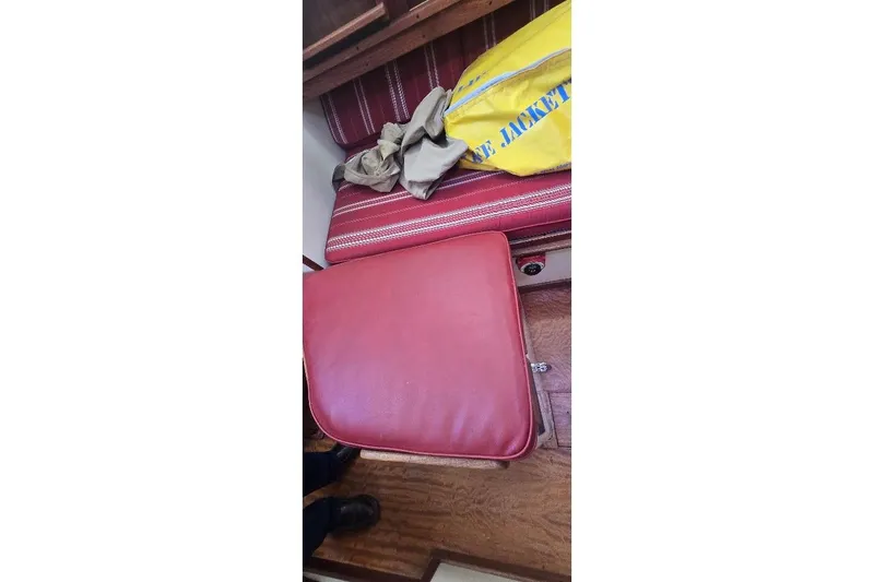 Slide: The Image of Interior of a 1978 Tartan T34c sailboat with red seating and a yellow life jacket. - 56