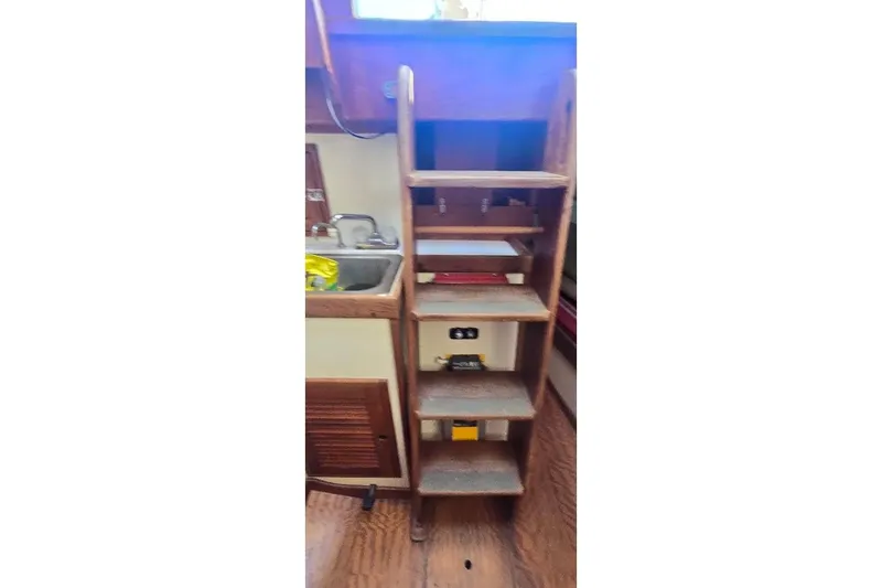 Slide: The Image of Interior of 1978 Tartan T34c sailboat with wooden steps and compact kitchen area. - 69
