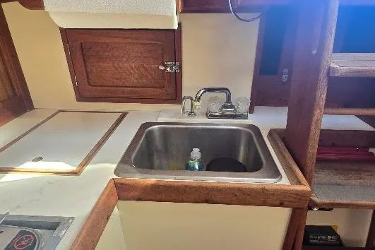 Slide: The Image of 1978 Tartan T34c yacht galley with sink, wooden cabinetry, and countertop. - 70