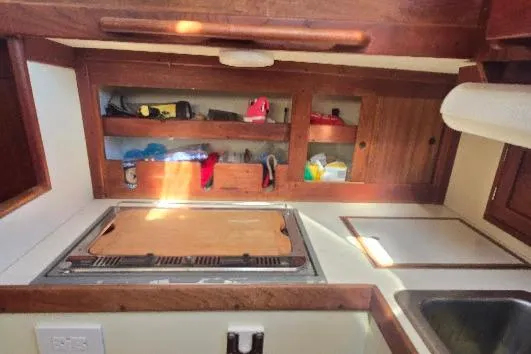 Slide: The Image of 1978 Tartan T34c sailboat galley with wooden cabinetry and countertop. - 72