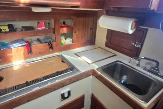 Slide: The Image of 1978 Tartan T34c yacht kitchen with sink, stove, and wooden cabinetry. - 75