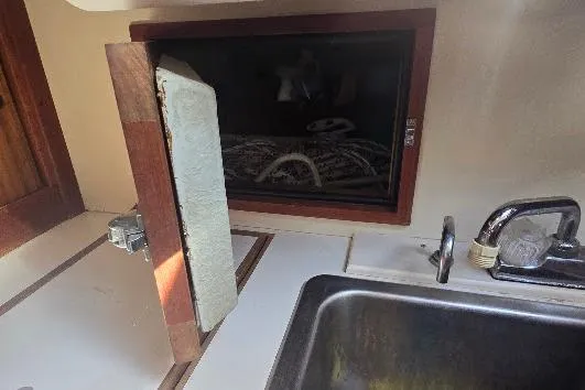 Slide: The Image of 1978 Tartan T34c yacht galley with open storage compartment and sink. - 76