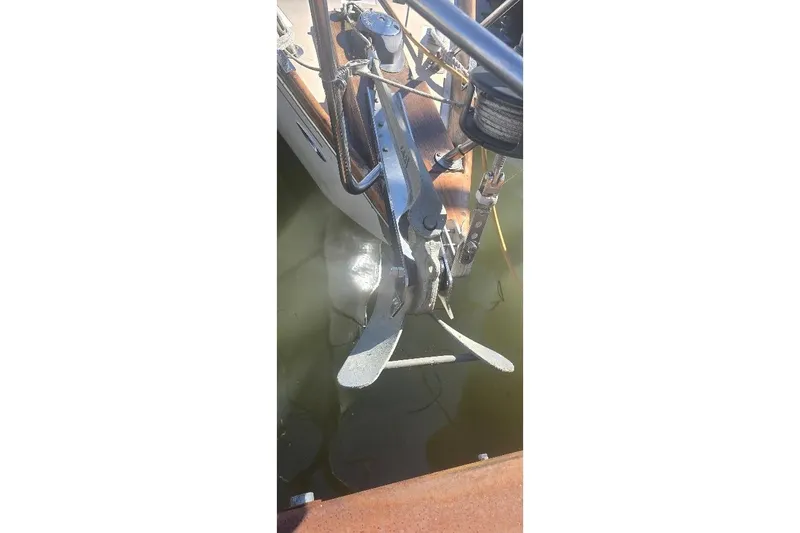 Slide: The Image of 1978 Tartan T34c sailboat anchor detail in water, showcasing metal fittings and rigging. - 8