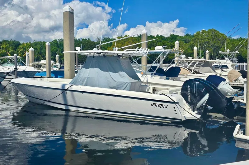 The Image of 2008 Intrepid 323 OPEN boat docked at marina, featuring twin Mercury outboard engines. - 1