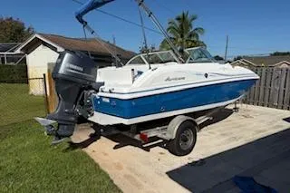 Slide: The Image of 2013 Hurricane SunDeck 187 OB boat on trailer, parked in a sunny backyard. - 1