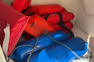 Slide: The Image of Red life jackets and blue fenders stored on a 2013 Hurricane SunDeck 187 OB boat. - 16