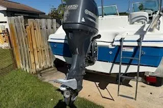 Slide: The Image of 2013 Hurricane SunDeck 187 OB boat with Yamaha outboard motor, parked on grass. - 6